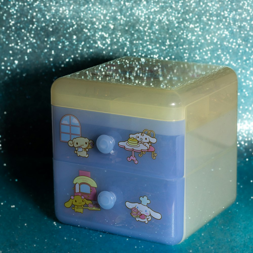a blue and yellow plastic box with cartoon characters on it