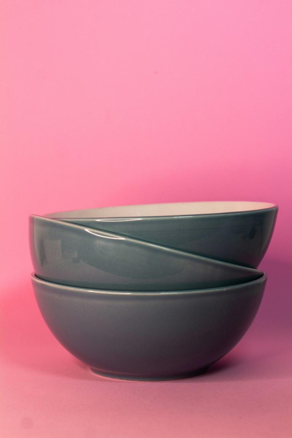 a couple of bowls sitting on top of a pink table