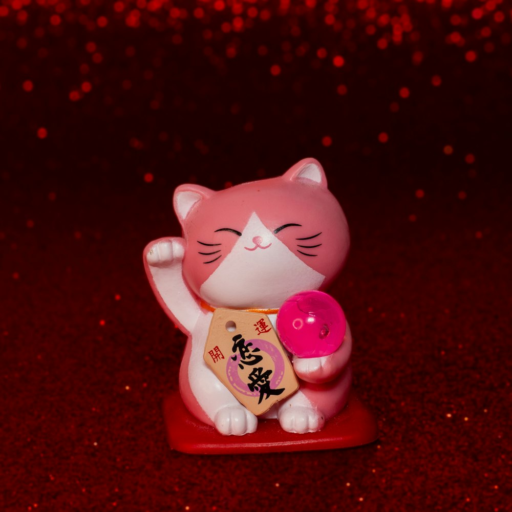 a small figurine of a cat holding a donut