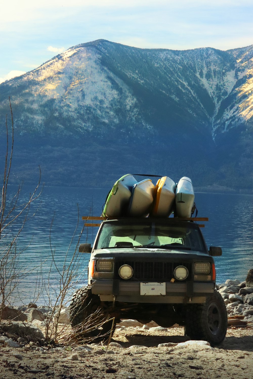 a jeep with two kayaks on top of it