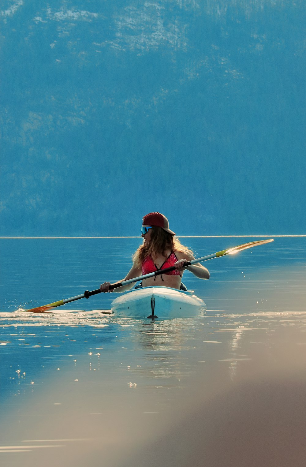 a woman is paddling a kayak in the water