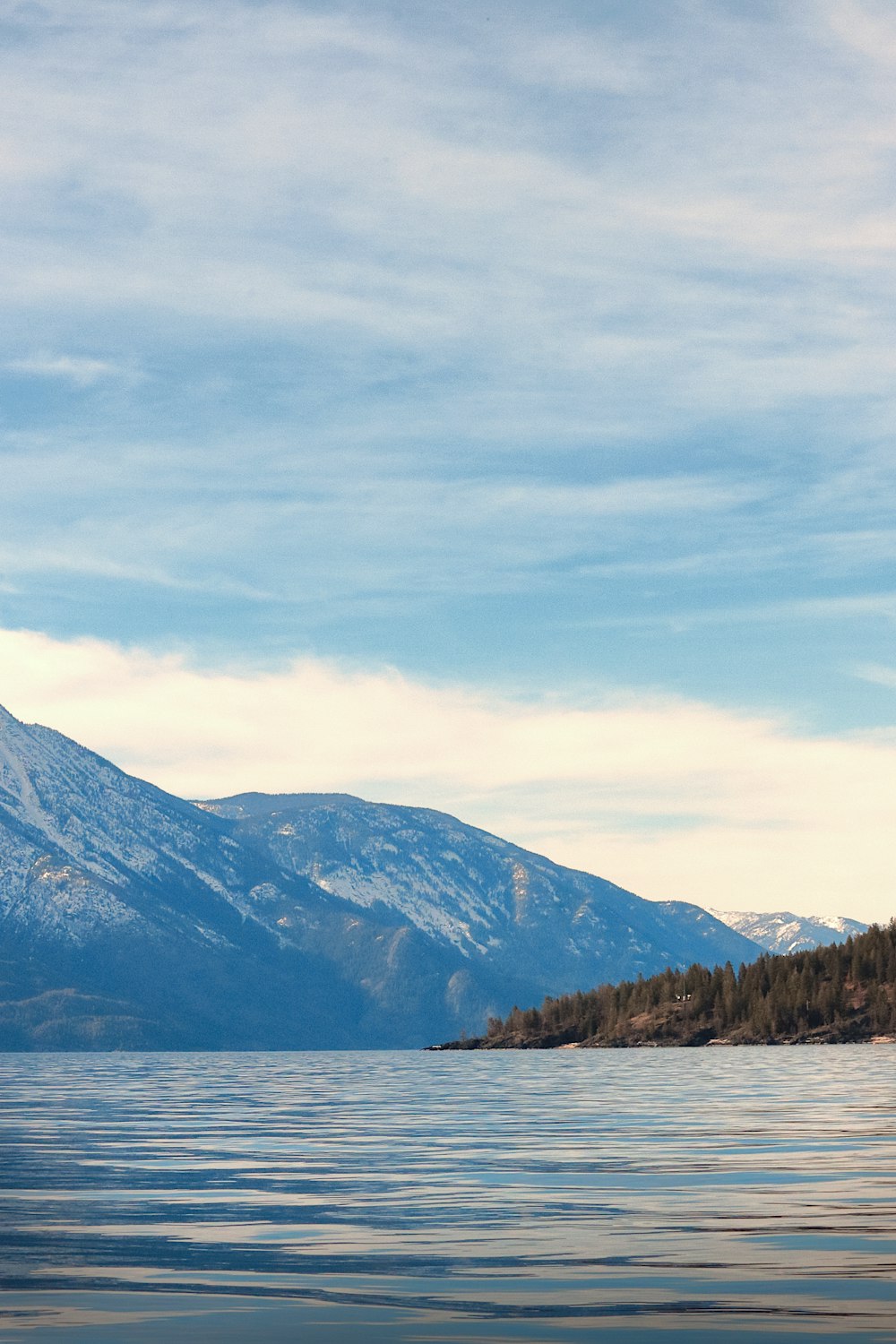 a large body of water with a mountain in the background