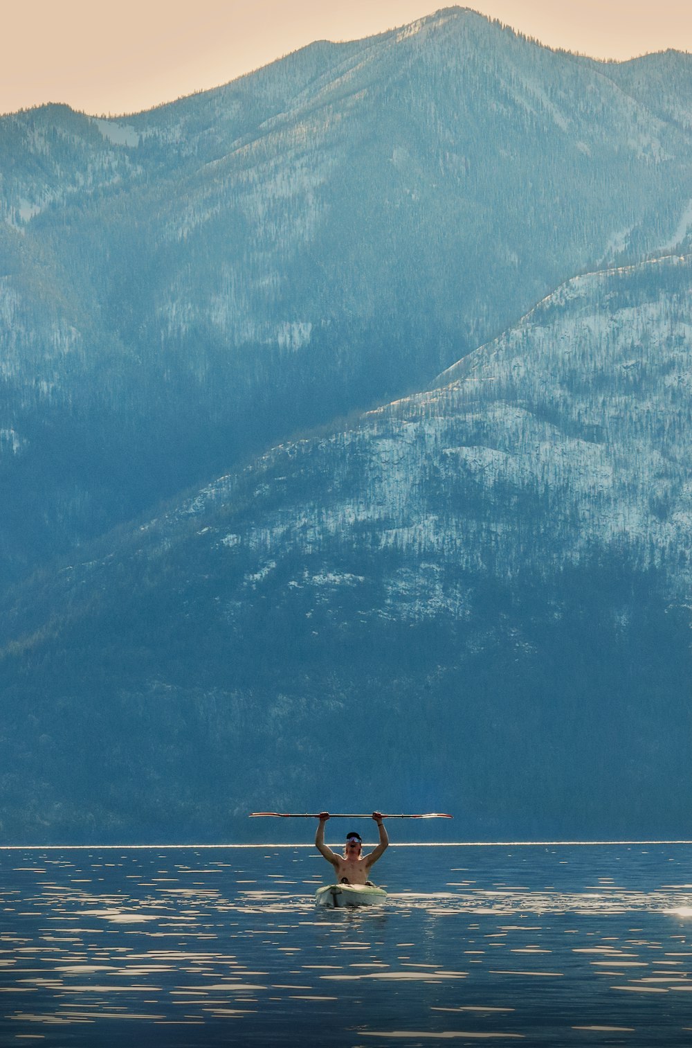 a man riding a paddle board on top of a lake