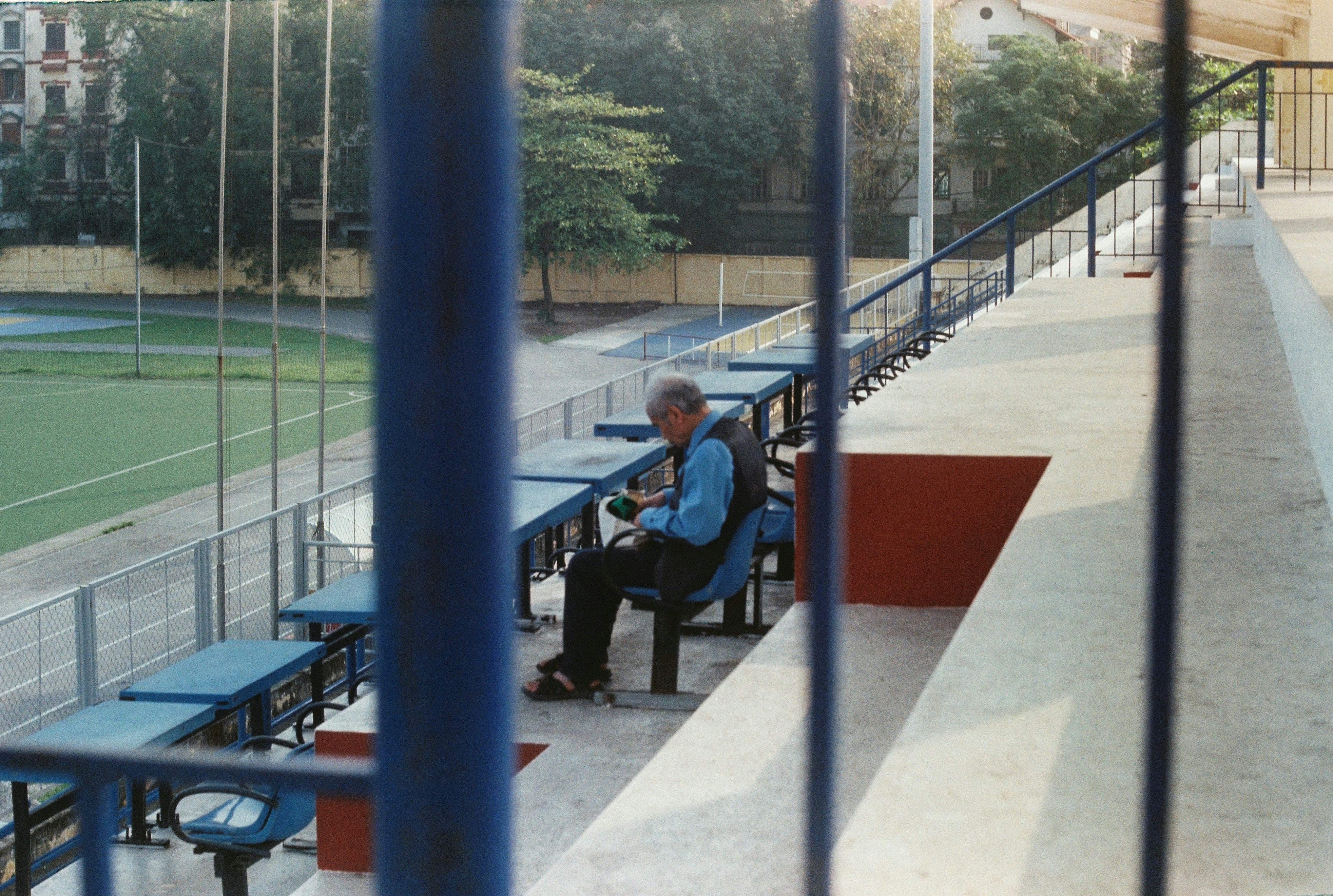 a man sitting on a bench at a baseball field