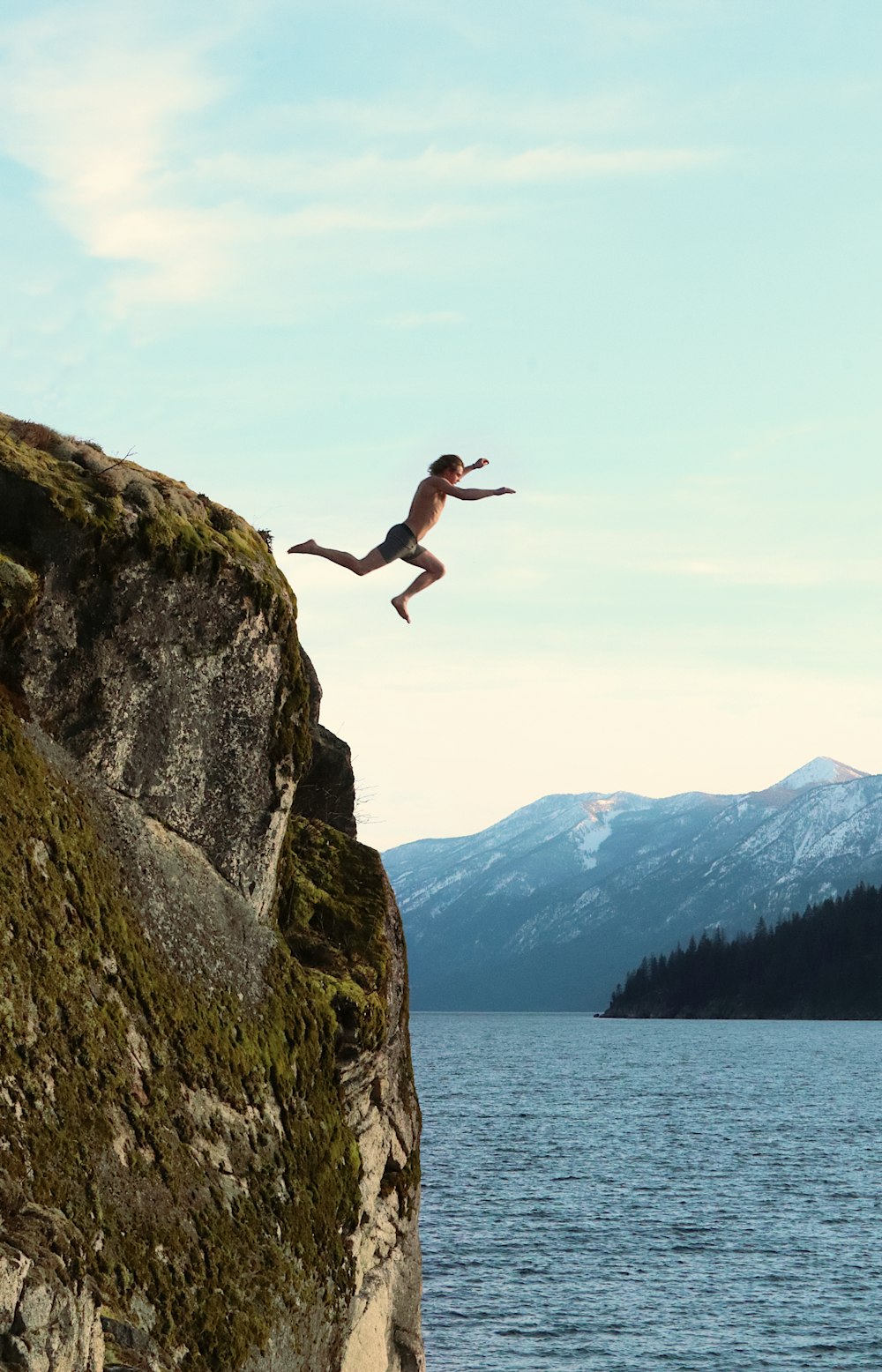 a person jumping off a cliff into a body of water