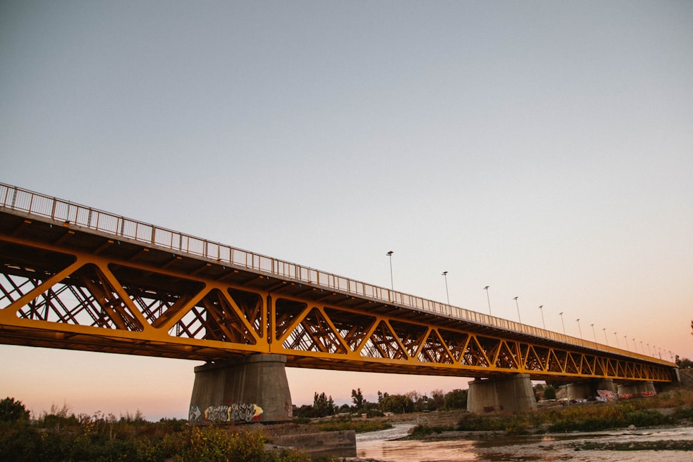 a yellow bridge over a body of water