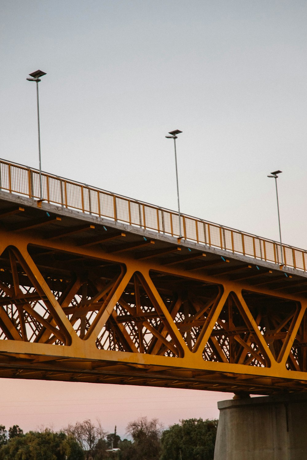 a yellow bridge with a train going over it