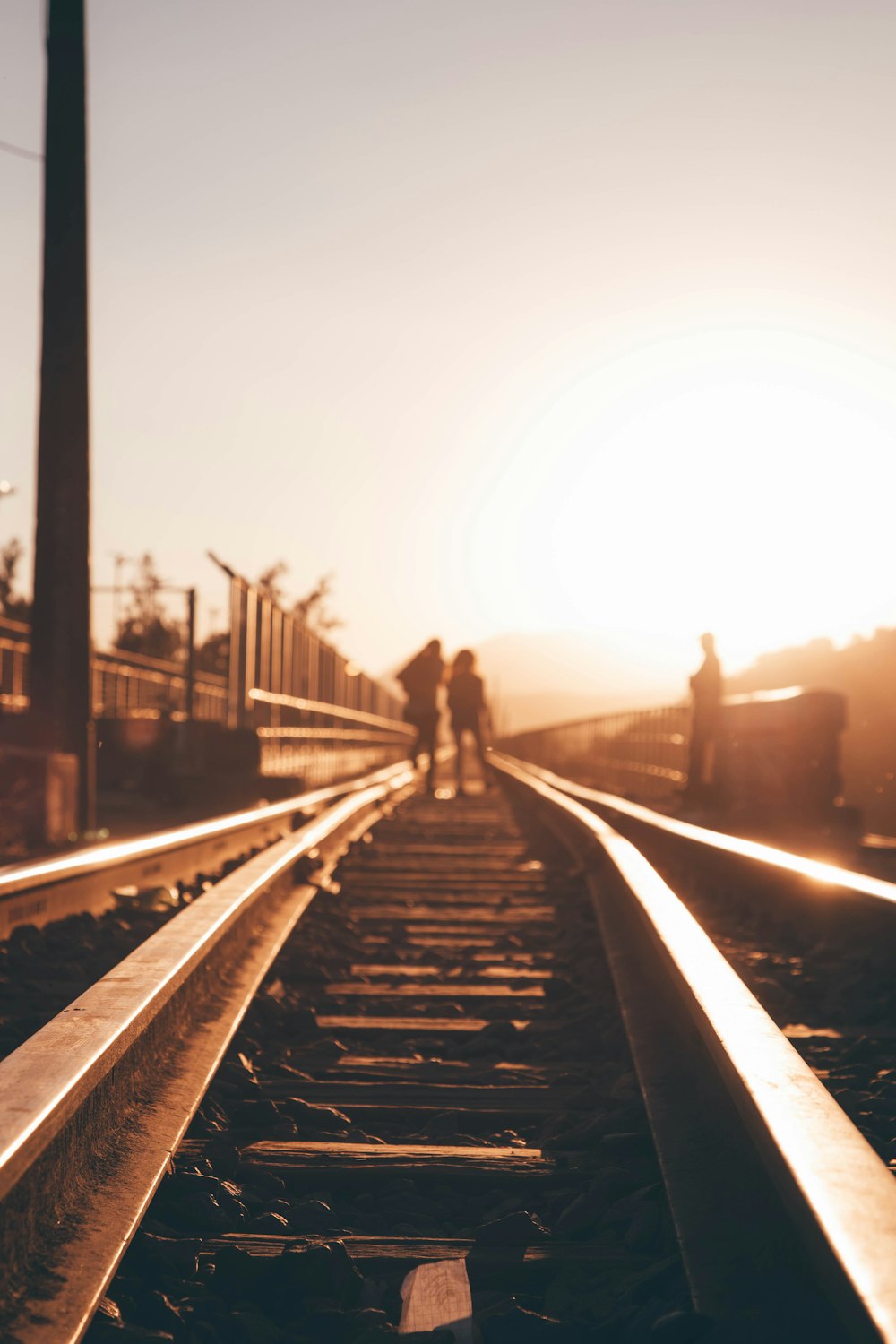 a couple of people standing on a train track