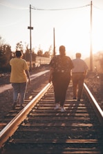 a group of people walking down a train track