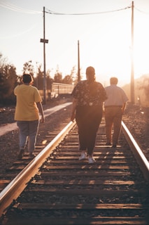 a group of people walking down a train track