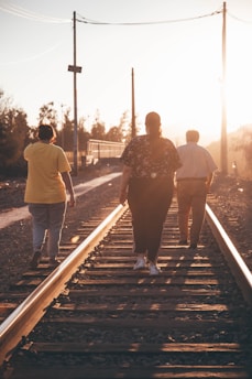 a group of people walking down a train track