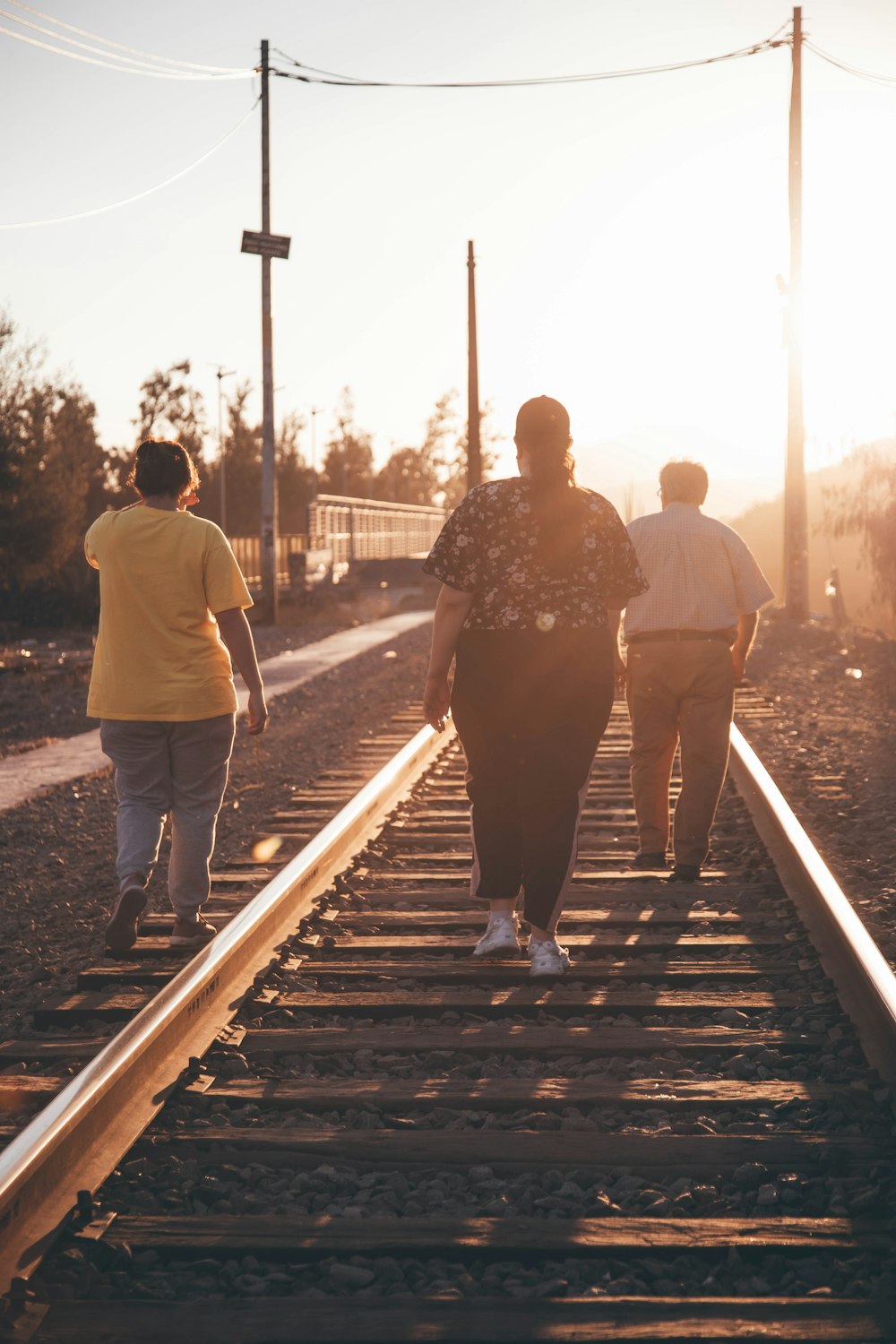 a group of people walking down a train track