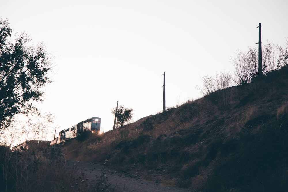 a train traveling down a train track next to a hillside