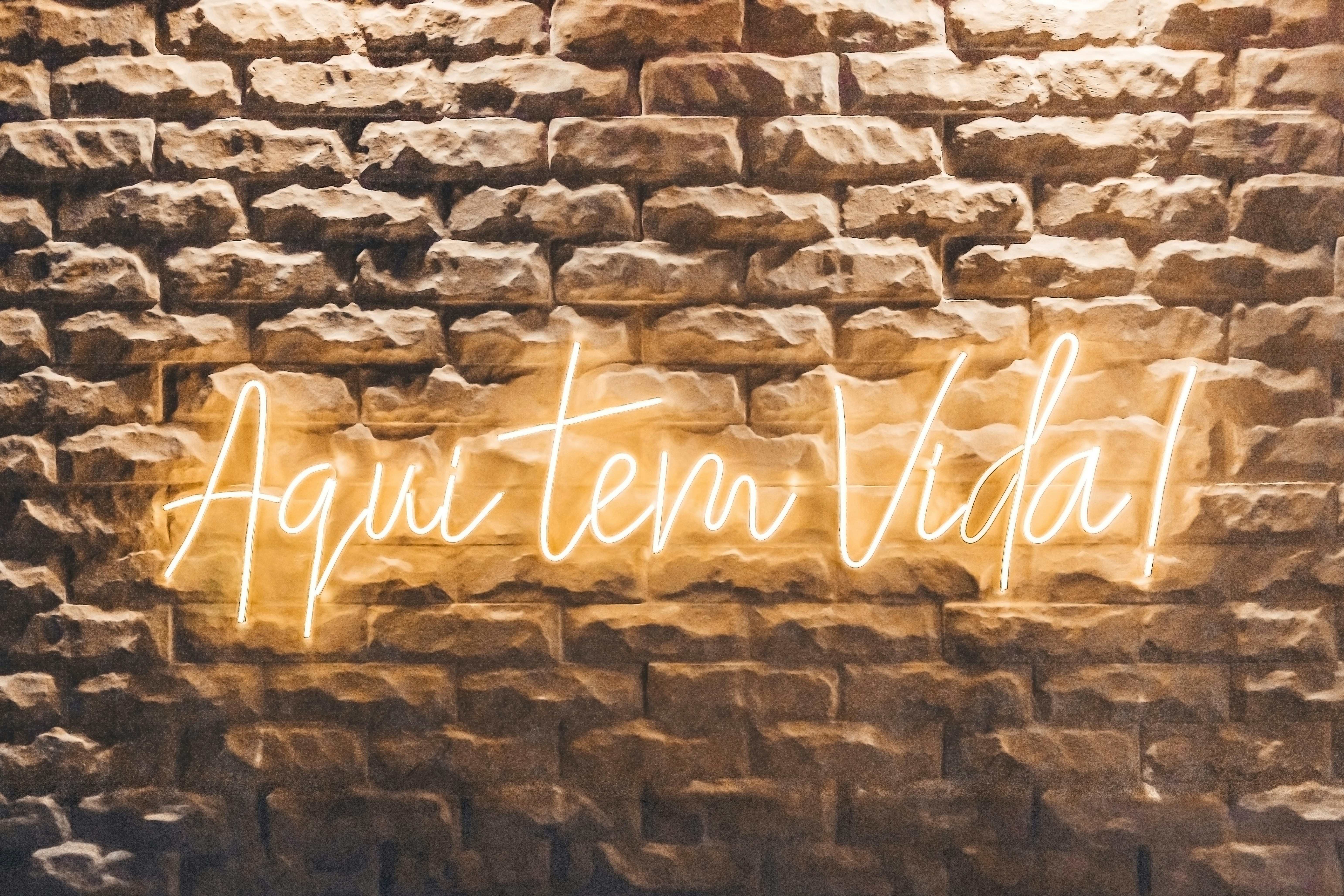 eine Backsteinmauer mit einer Leuchtreklame darauf