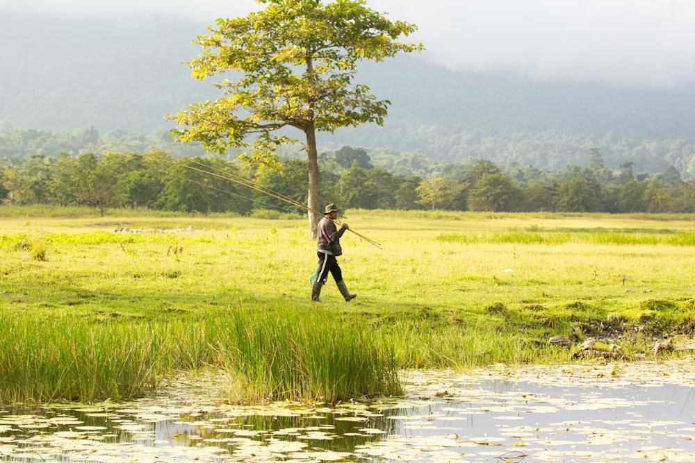 a man walking across a lush green field