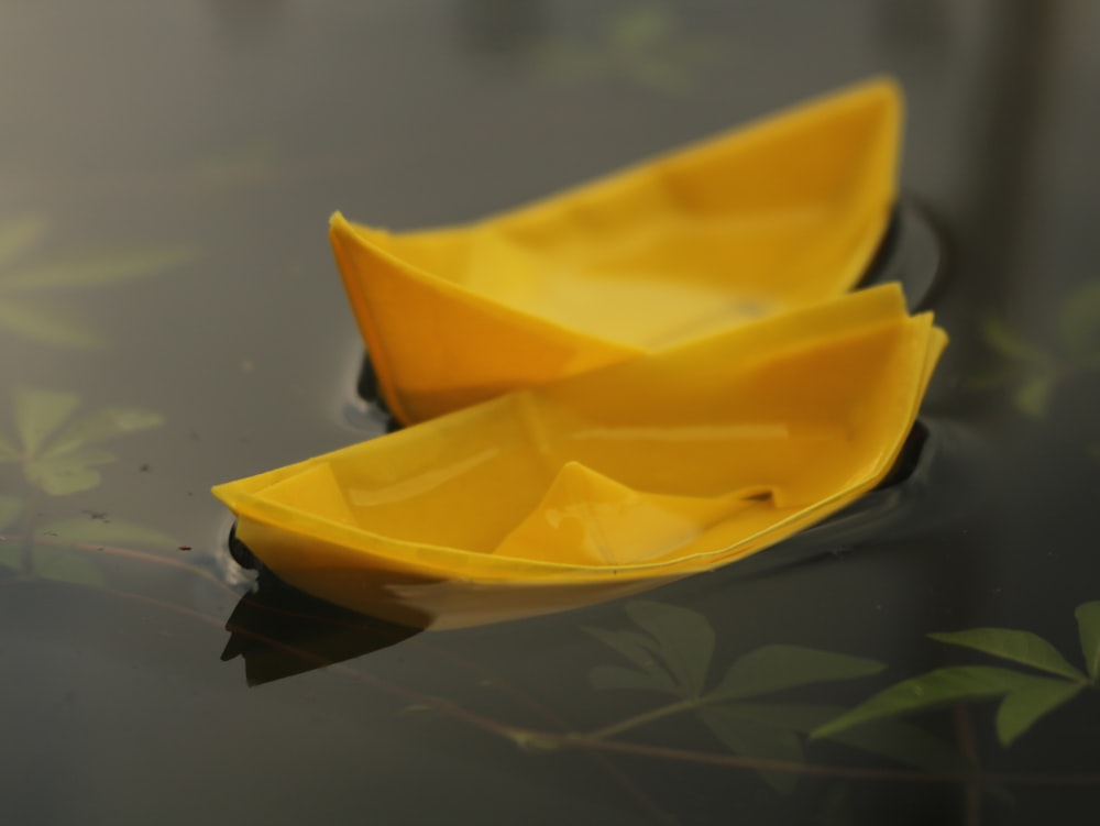 a couple of yellow boats floating on top of a lake