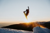 a man flying through the air while riding a snowboard