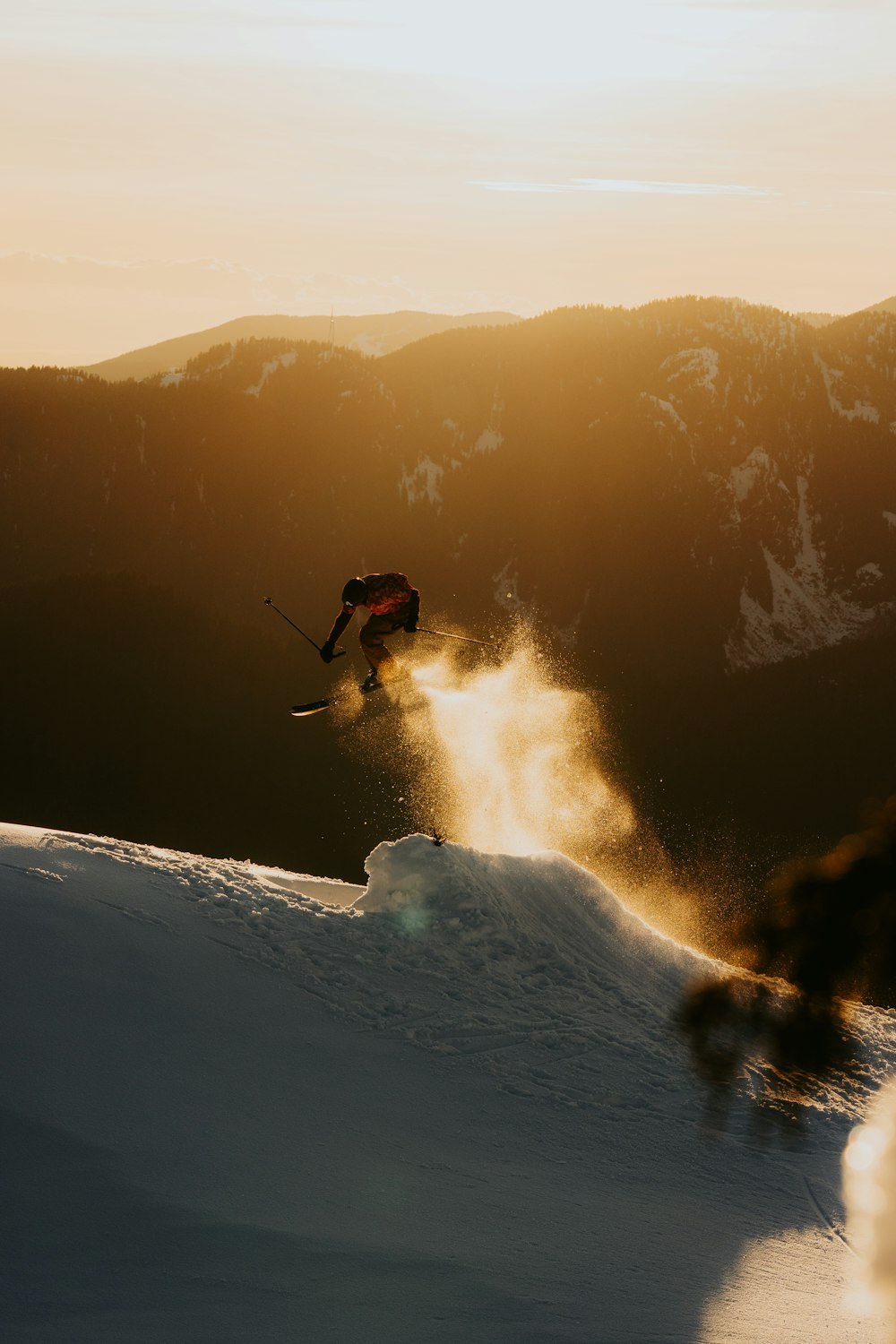 a person skiing down a snowy hill with mountains in the background