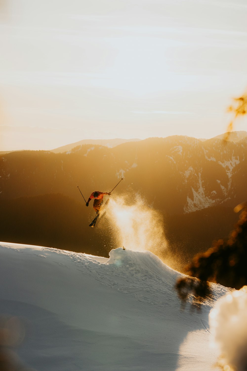 a person on skis jumping over a snowy hill