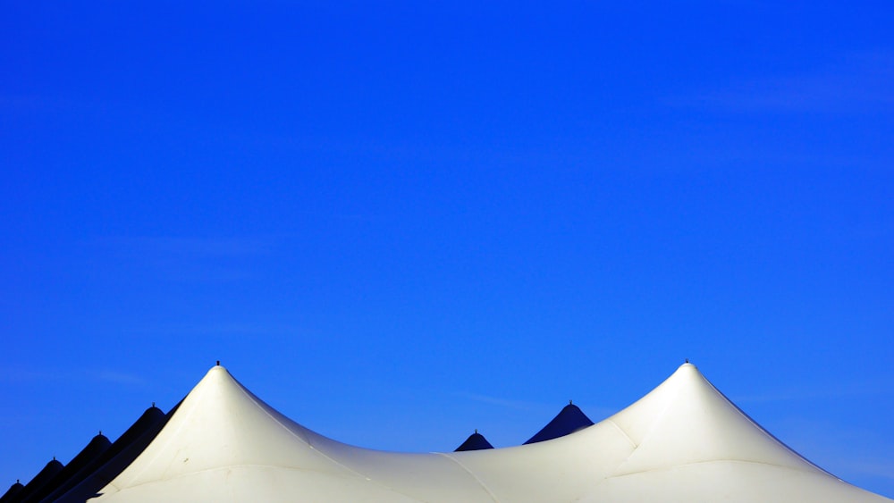 a large white tent sitting under a blue sky