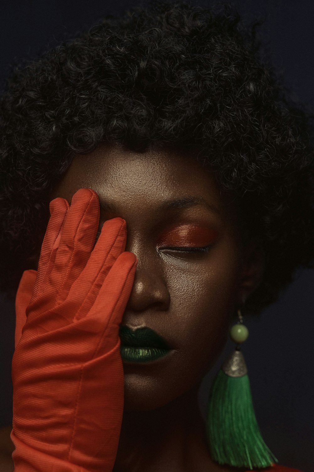 a woman with red lipstick and a green tassel