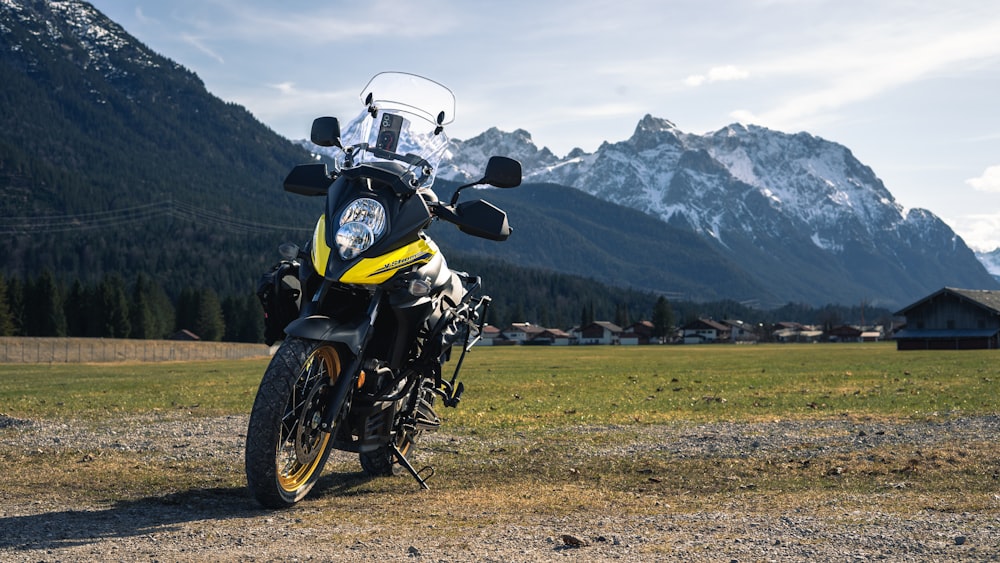 a yellow and black motorcycle parked in a field