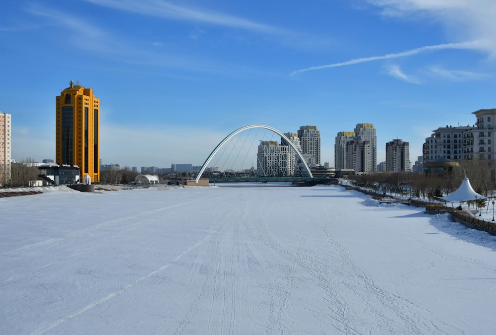 a wide open field with a bridge in the background