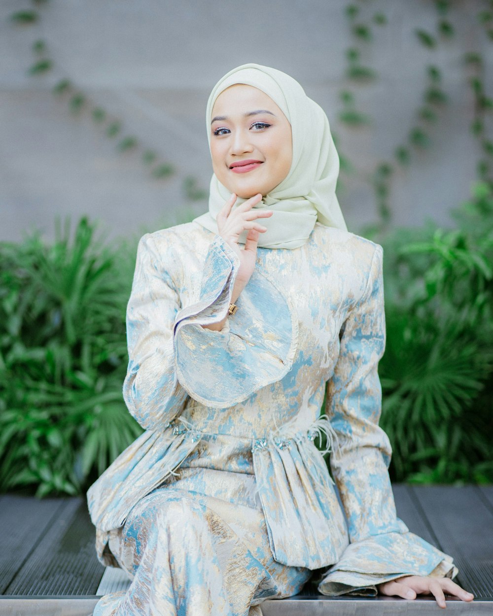 a woman wearing a hijab sitting on a bench