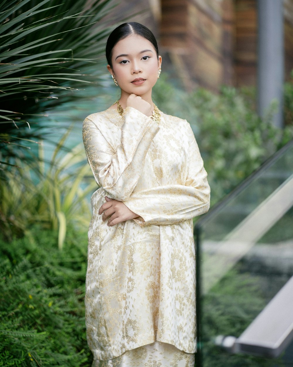 a woman standing in front of a green plant