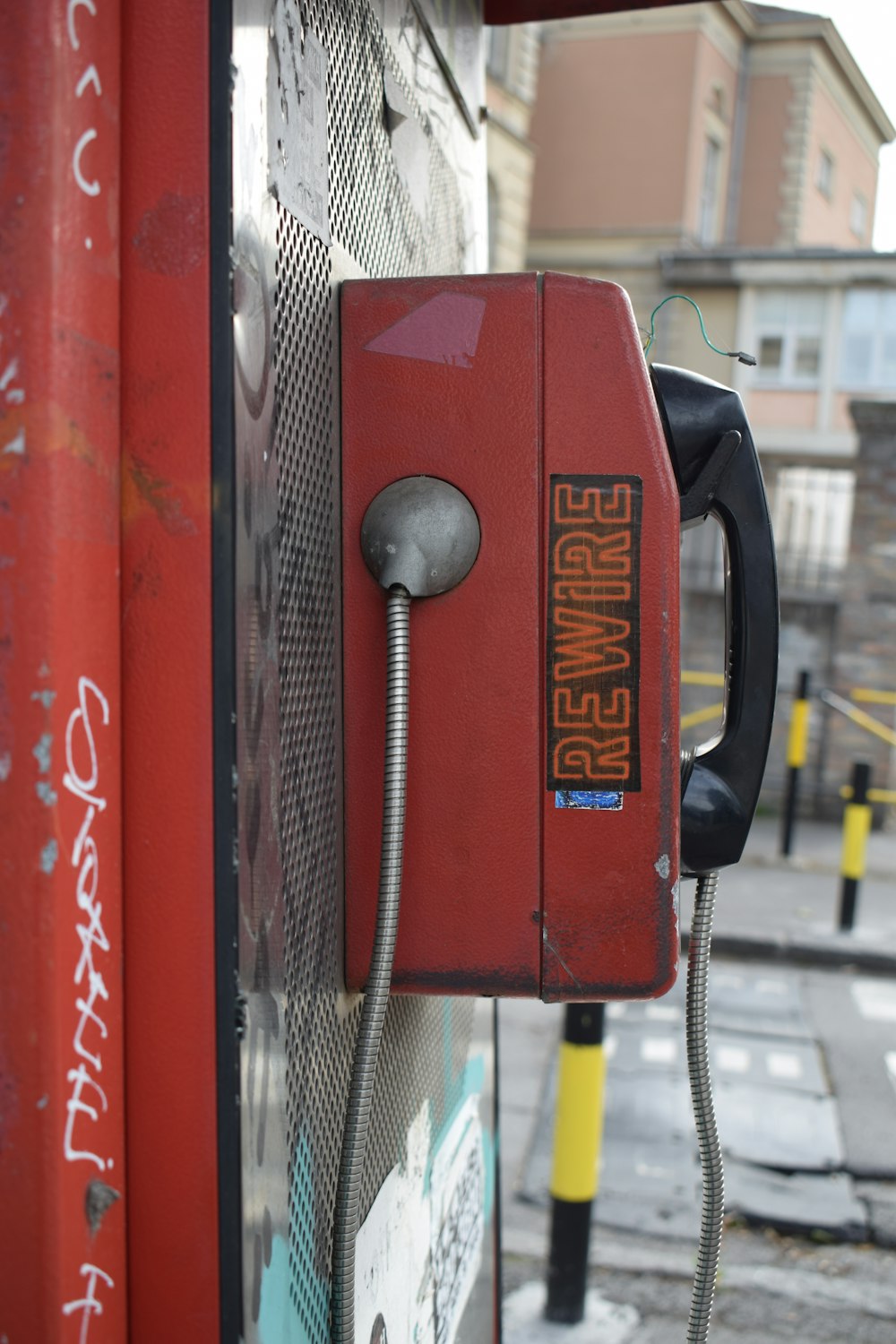 um telefone vermelho à moda antiga na lateral de um edifício