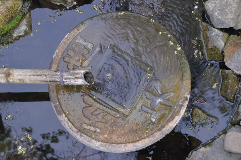 a metal object sitting on top of a puddle of water