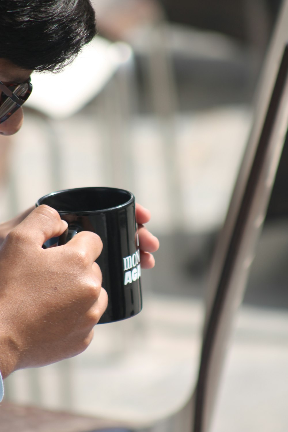 a man holding a black coffee mug in his right hand