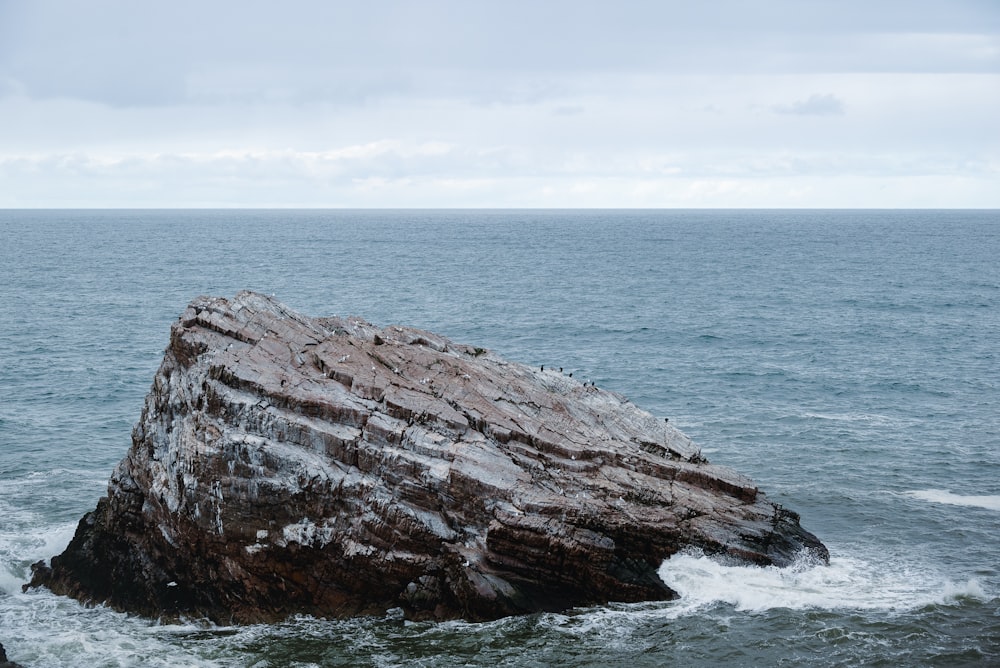 a large rock sticking out of the ocean