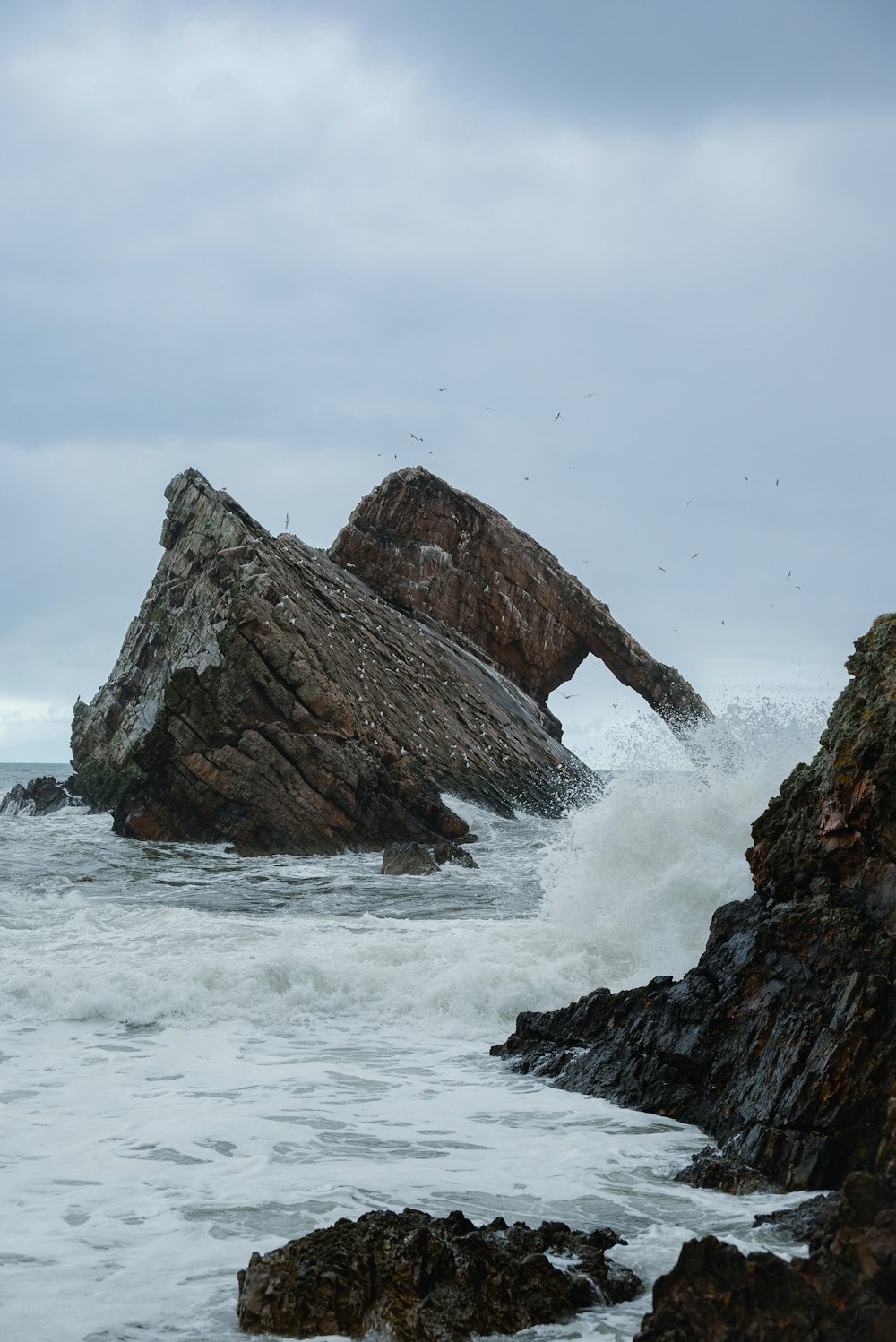 a large rock sticking out of the ocean