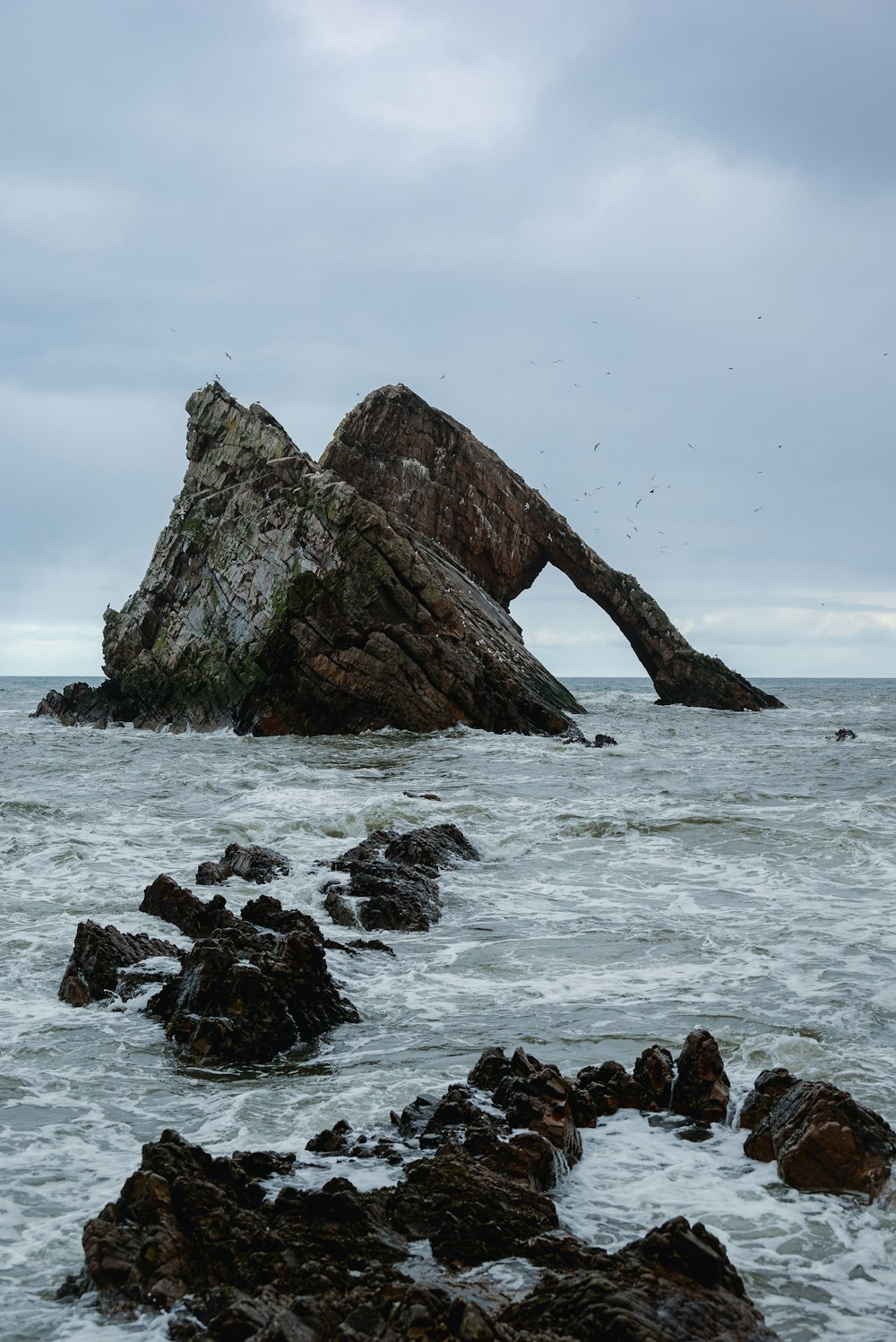 a large rock sticking out of the ocean