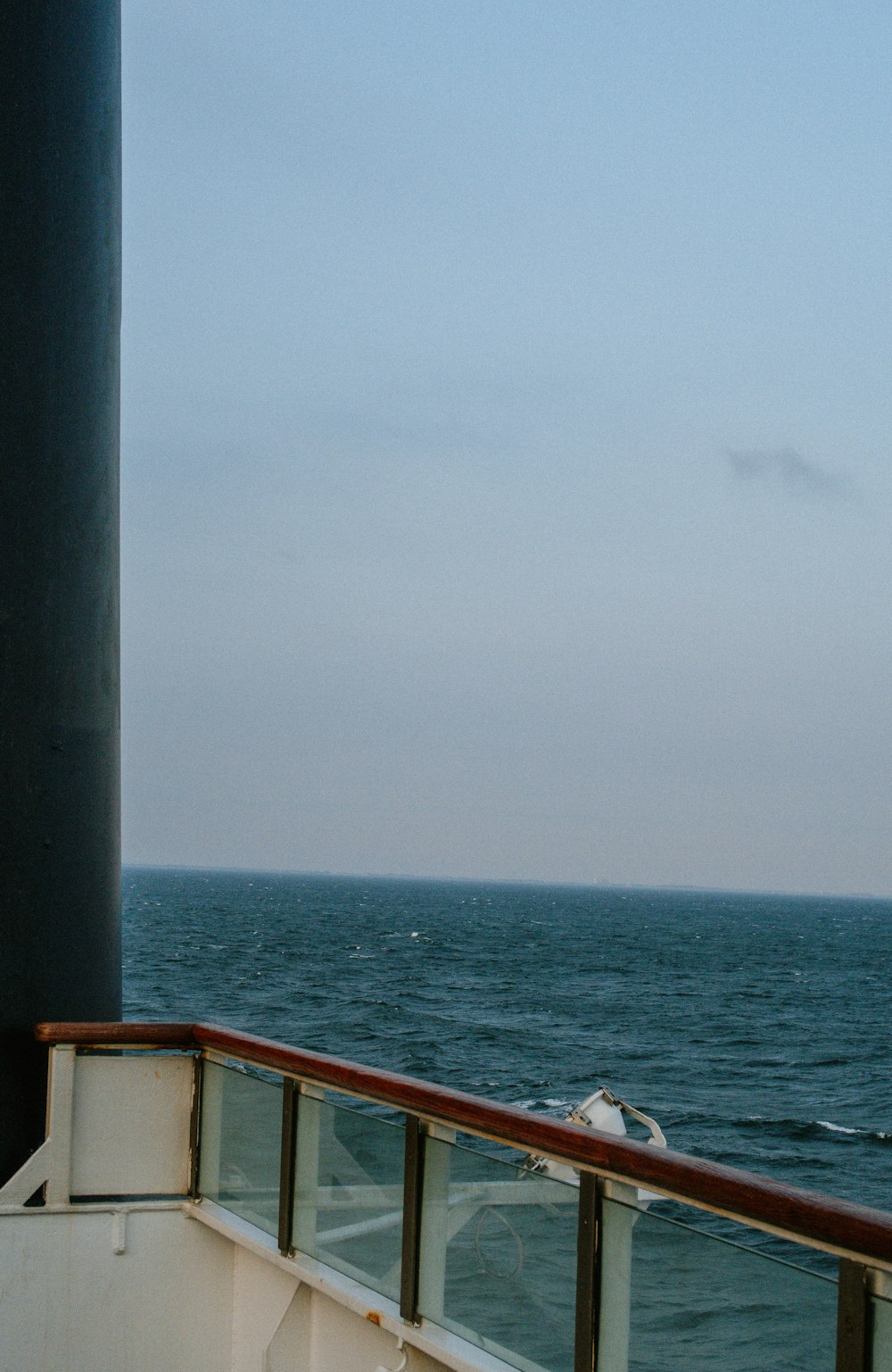 a seagull is sitting on the railing of a boat