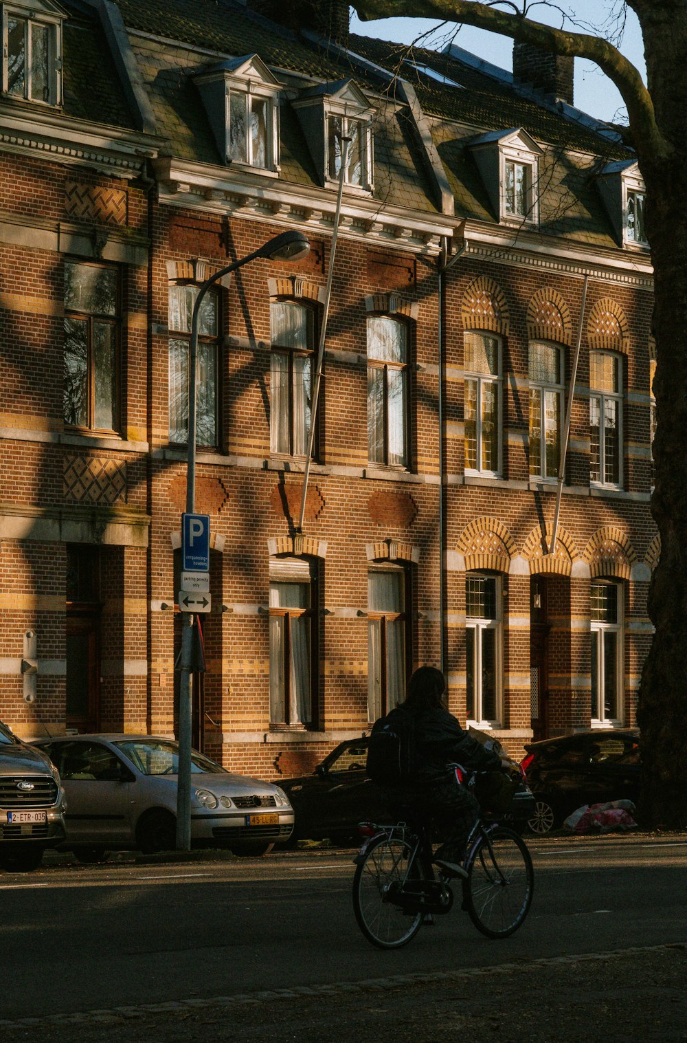 a person riding a bike down a street next to a tall building