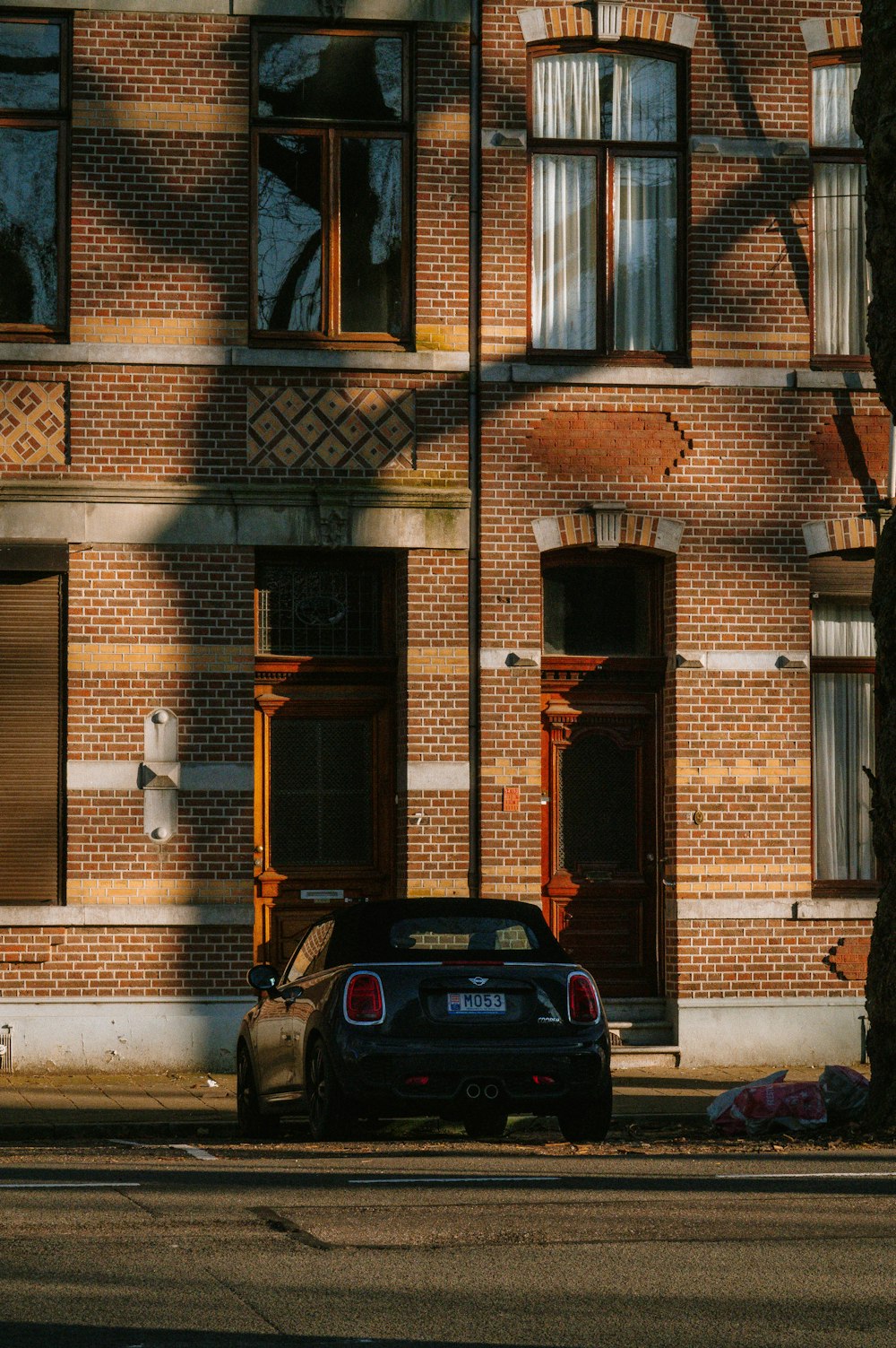 a car parked in front of a tall brick building