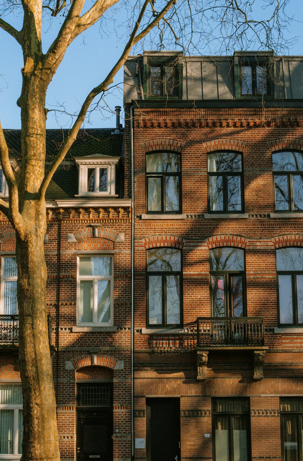 a tall brick building sitting next to a tree