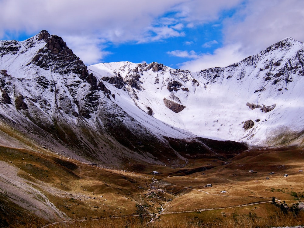 a snow covered mountain with a wire fence in the foreground