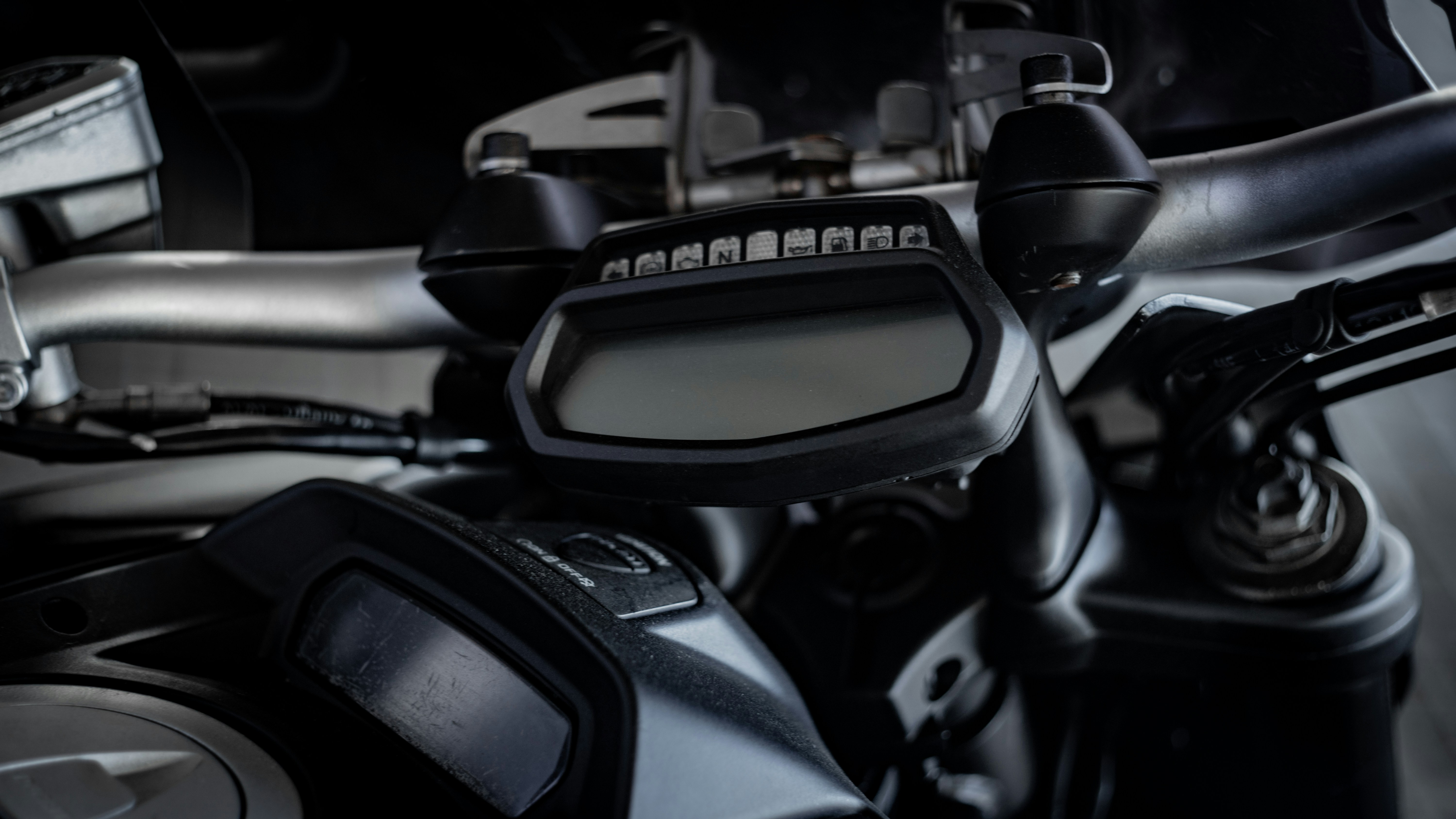 Motorcycle handlebars and digital dashboard controls.