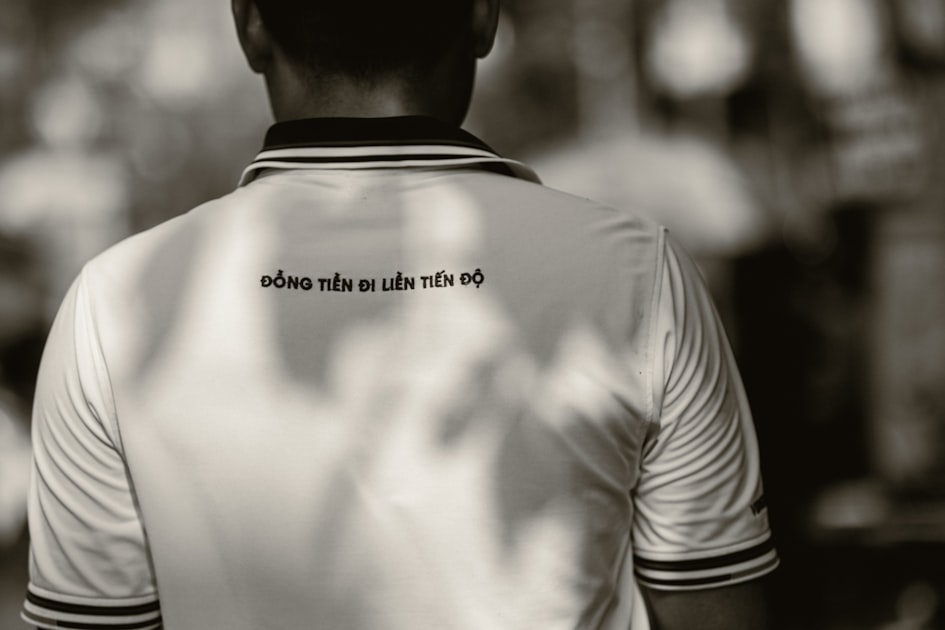 a man wearing a white shirt with black lettering on it