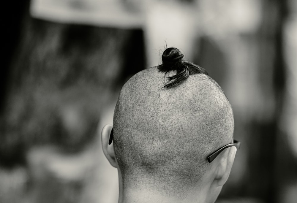 a bald man with a bun in his hair