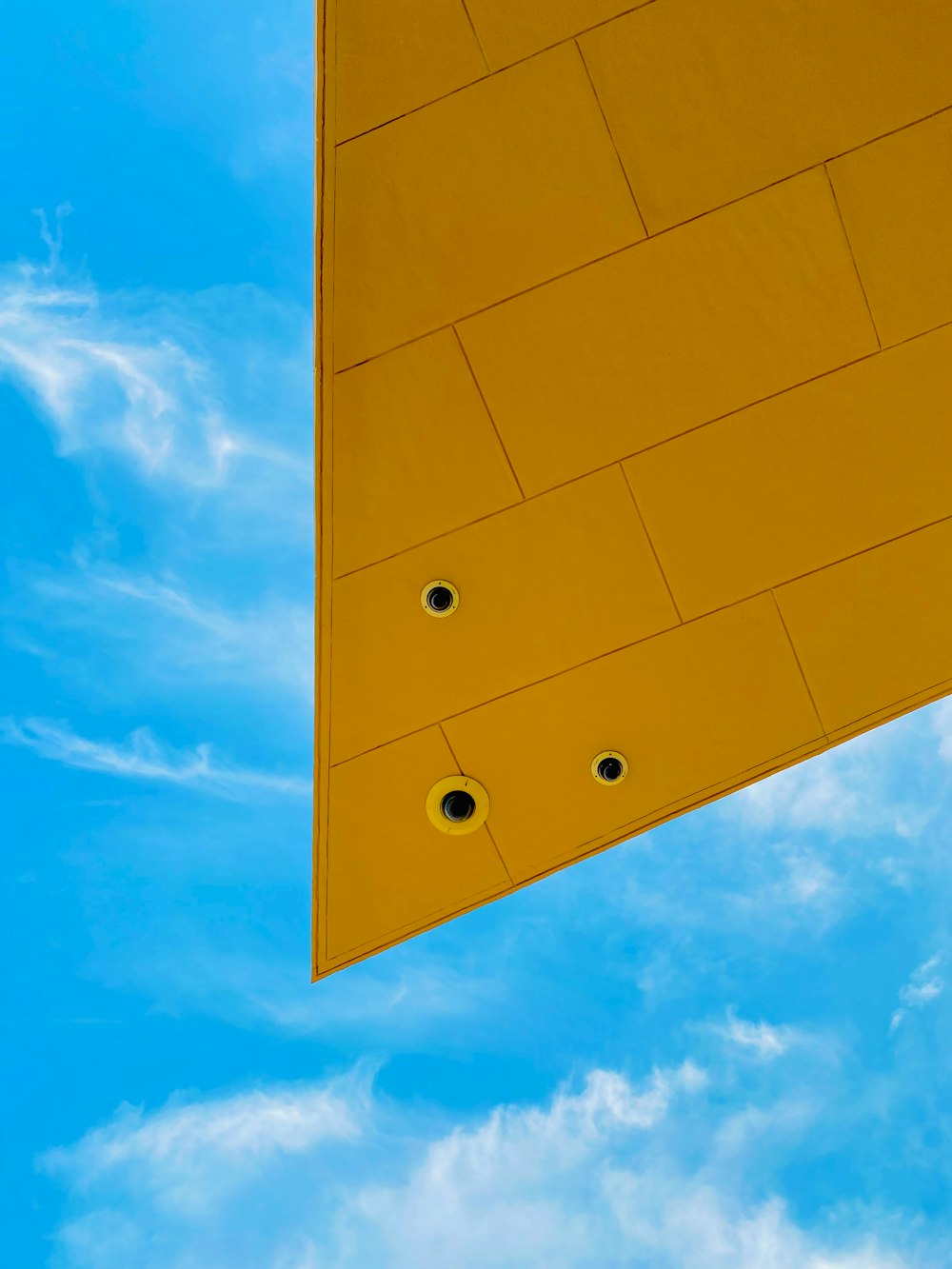 a yellow building with a blue sky in the background