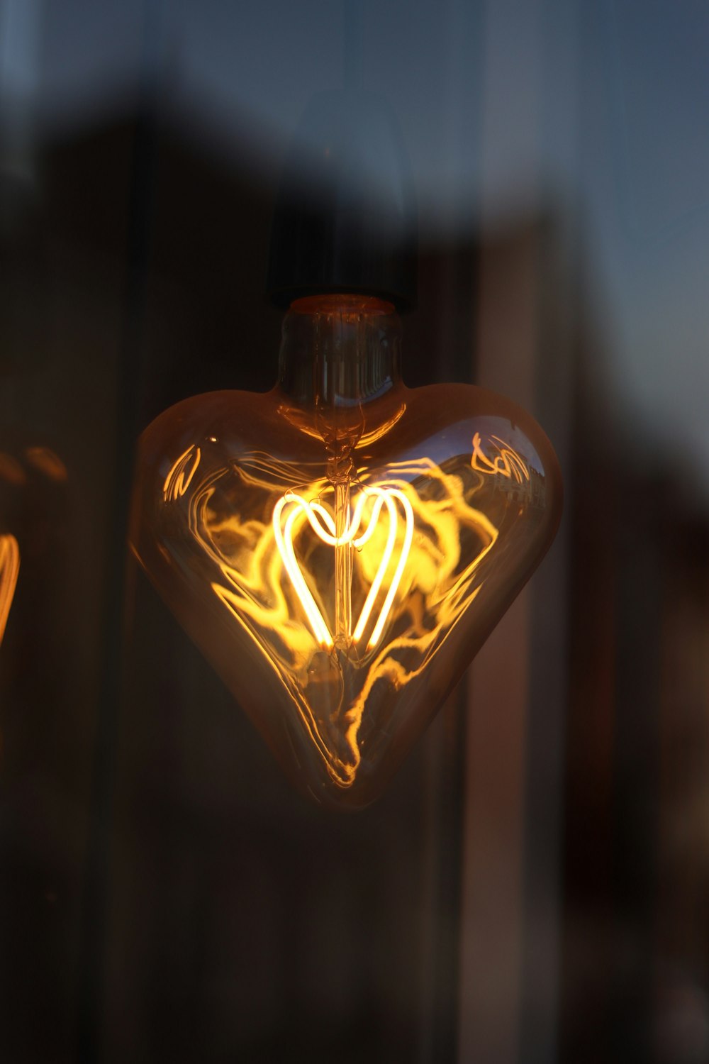 a heart shaped light bulb hanging from a window