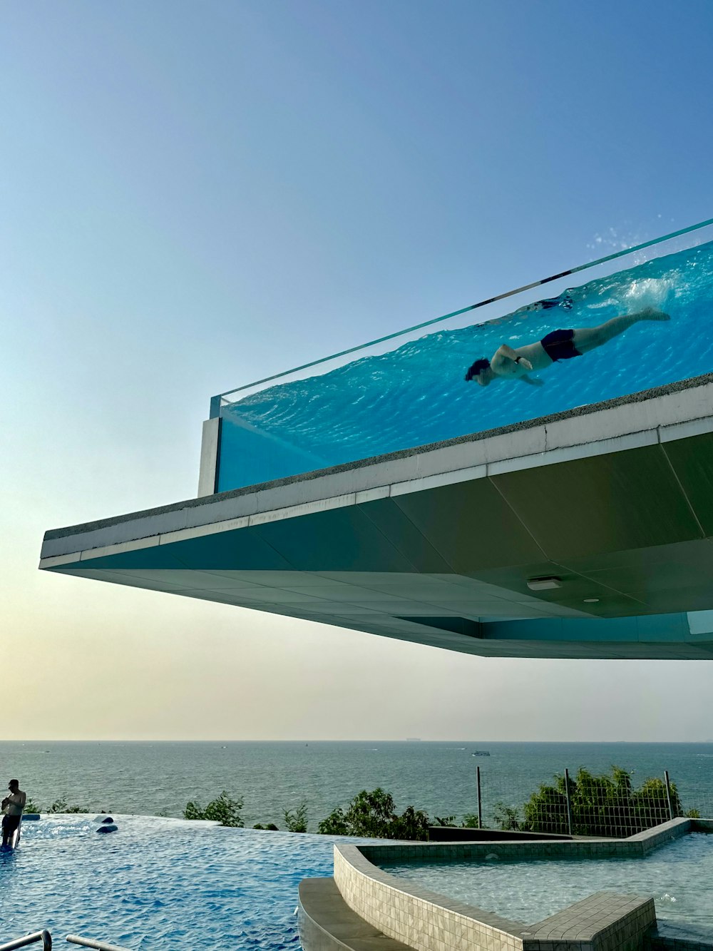 a person swimming in a pool under a blue sky