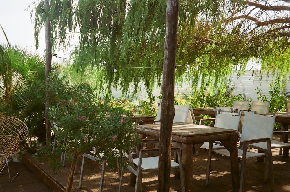 a patio with a table and chairs under a tree