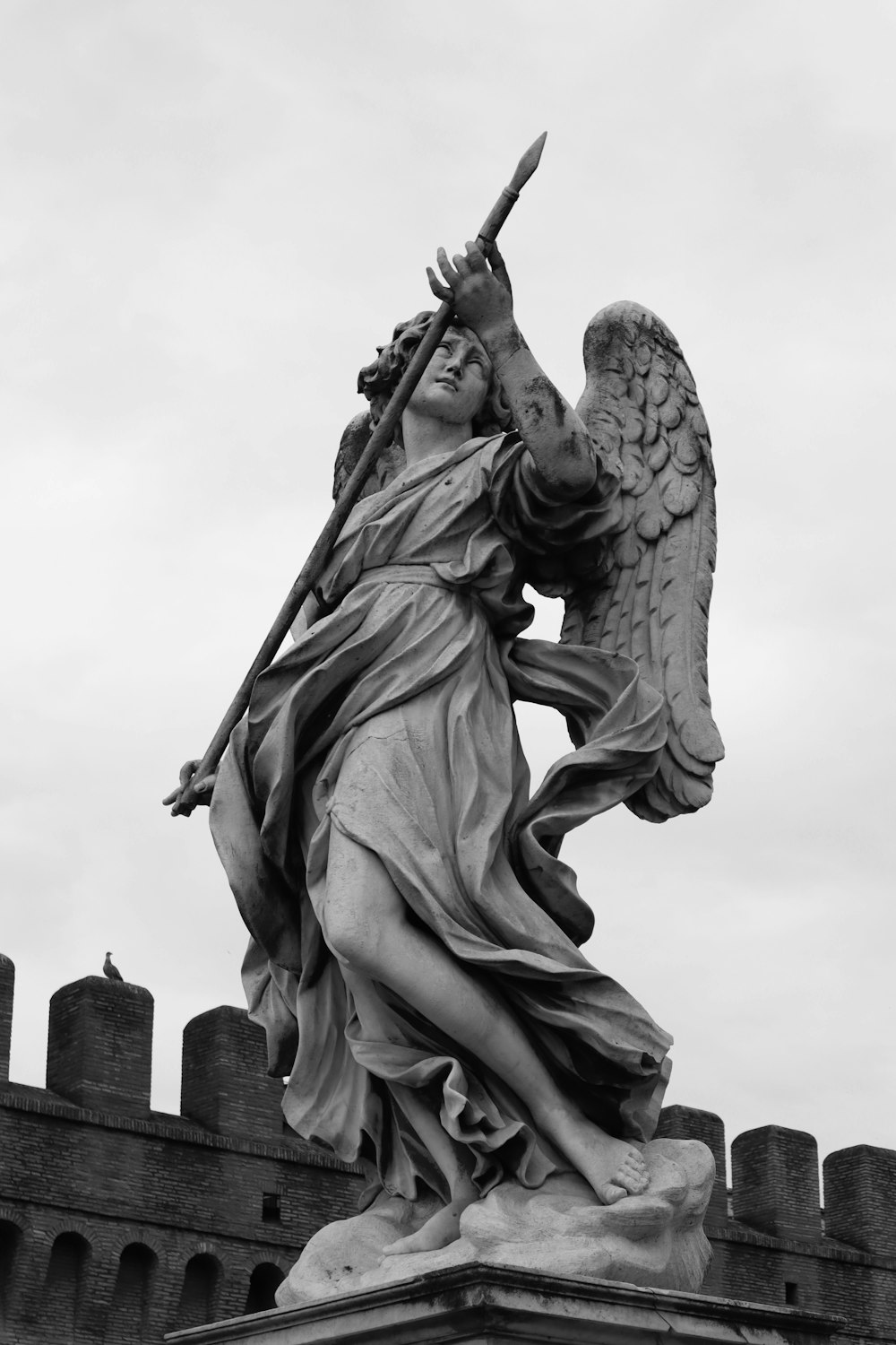 a black and white photo of a statue of an angel