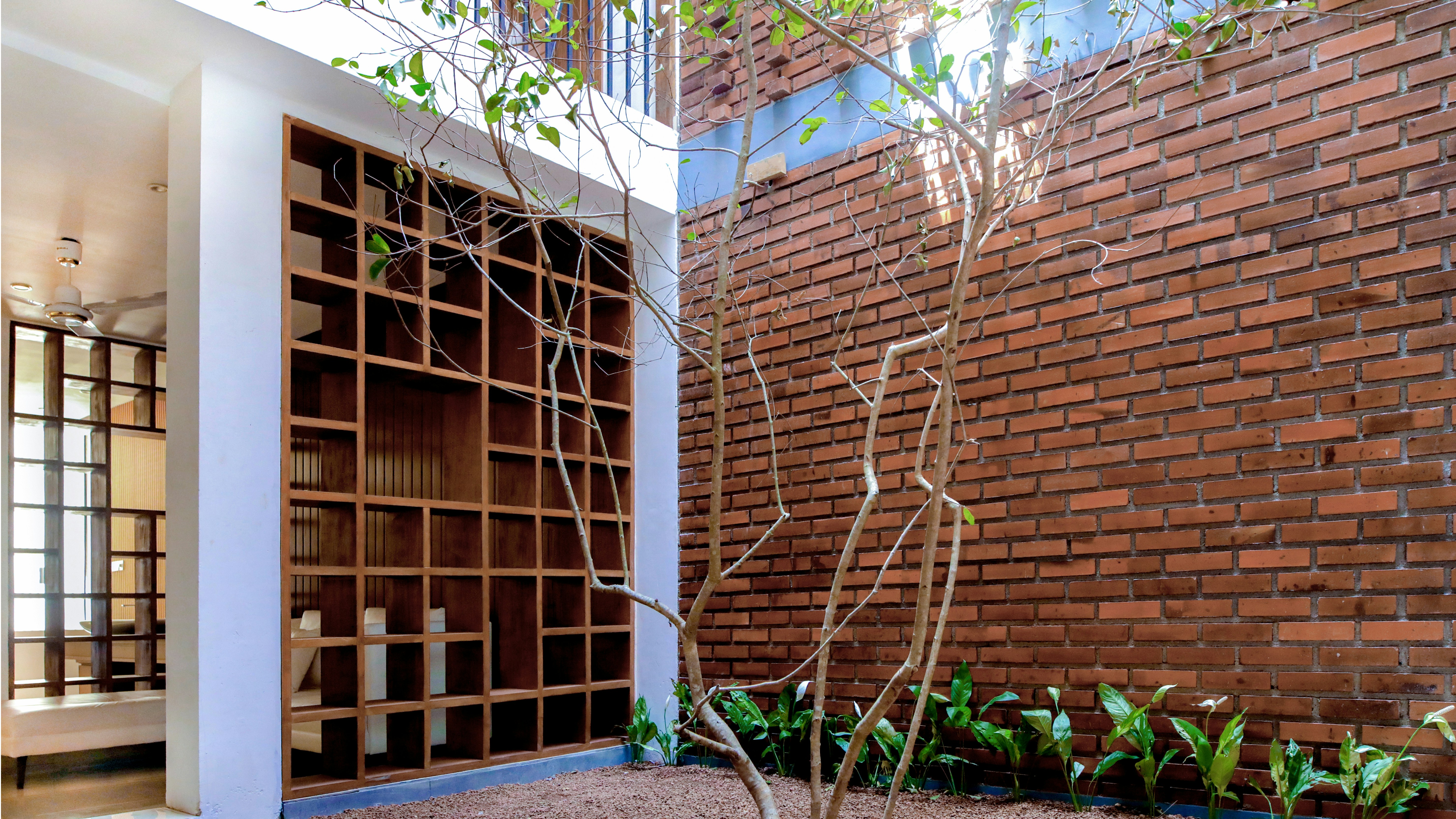 a room with a brick wall and a tree in the corner
