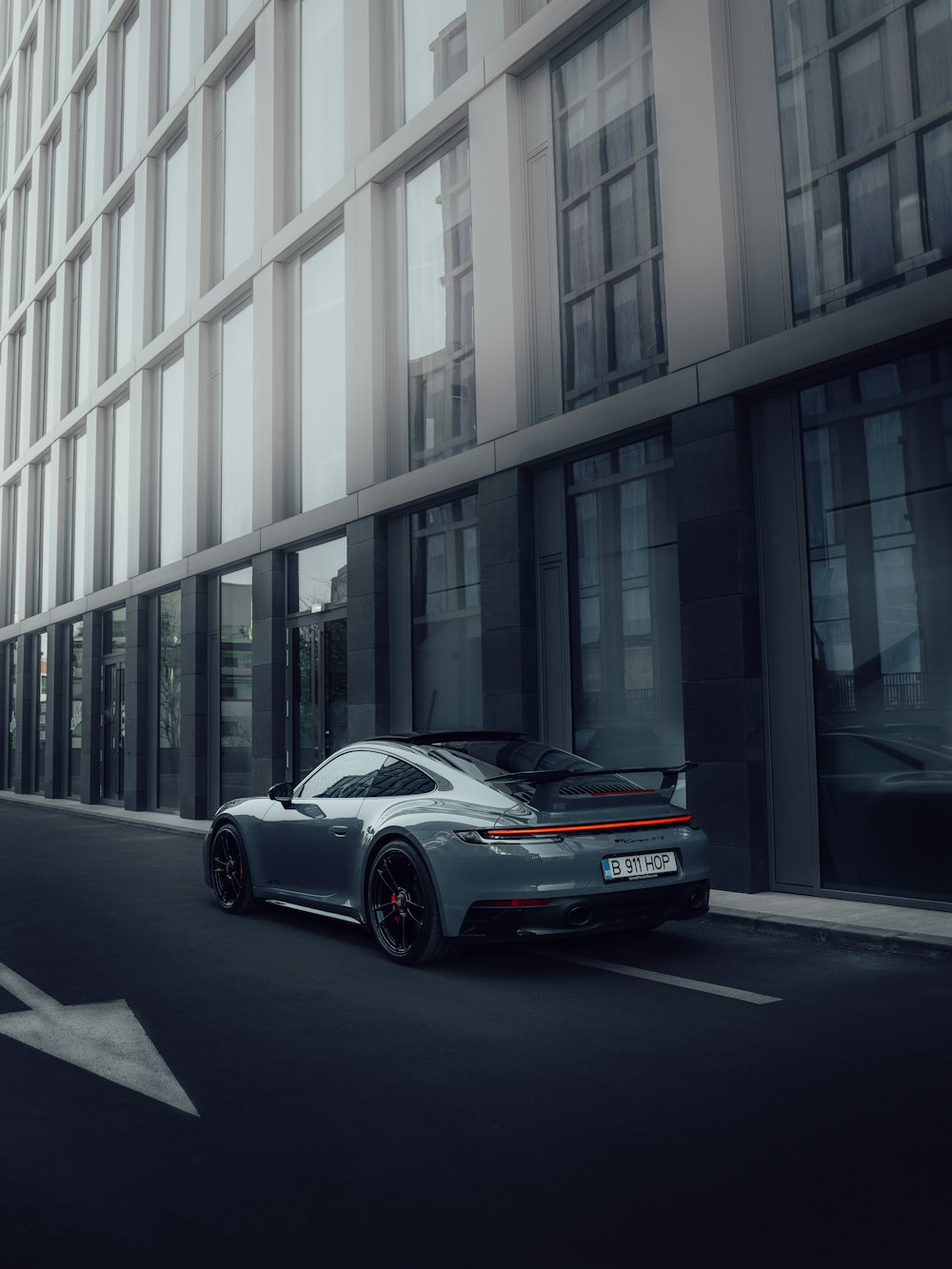 a grey sports car driving down a city street